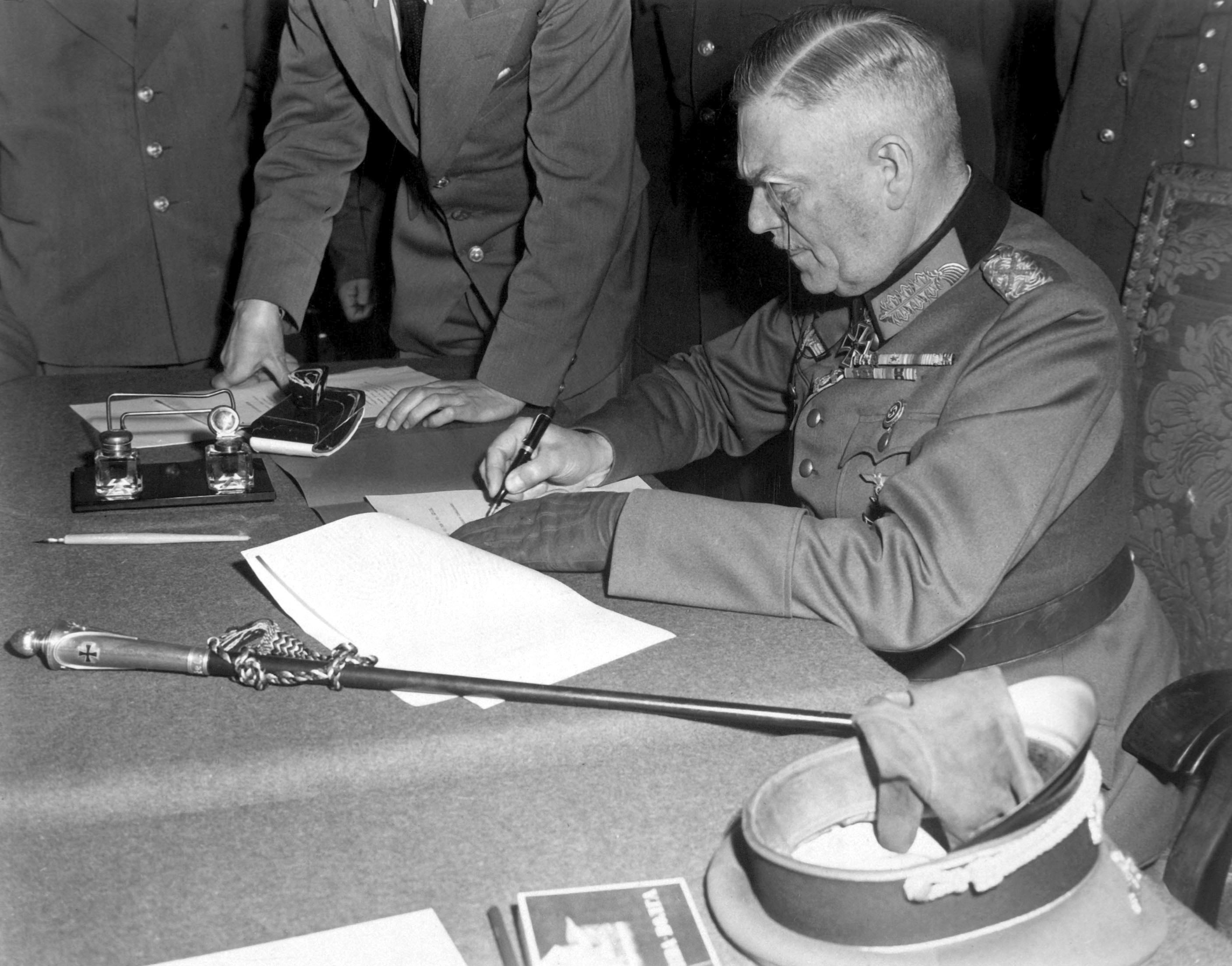 Feldmarszałek Wilhelm Keitel podpisuje warunki poddania niemieckiej armii w siedzibie rosyjskiej kwatery w Berlinie 7 maja 1945 roku (fot. Lt. Moore (US Army) - National Archives and Records Administration, źródło: domena publiczna).