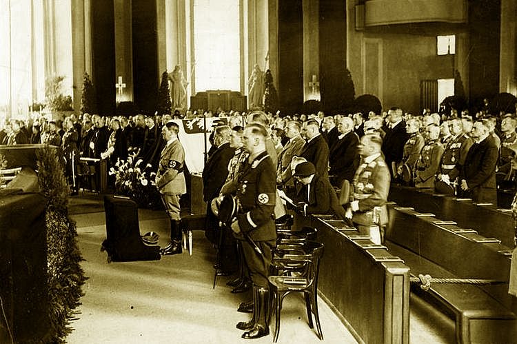 Adolf Hitler stoi obok symbolicznej trumny Józefa Piłsudskiego podczas uroczystości w katedrze św. Jadwigi (źródło: domena publiczna).