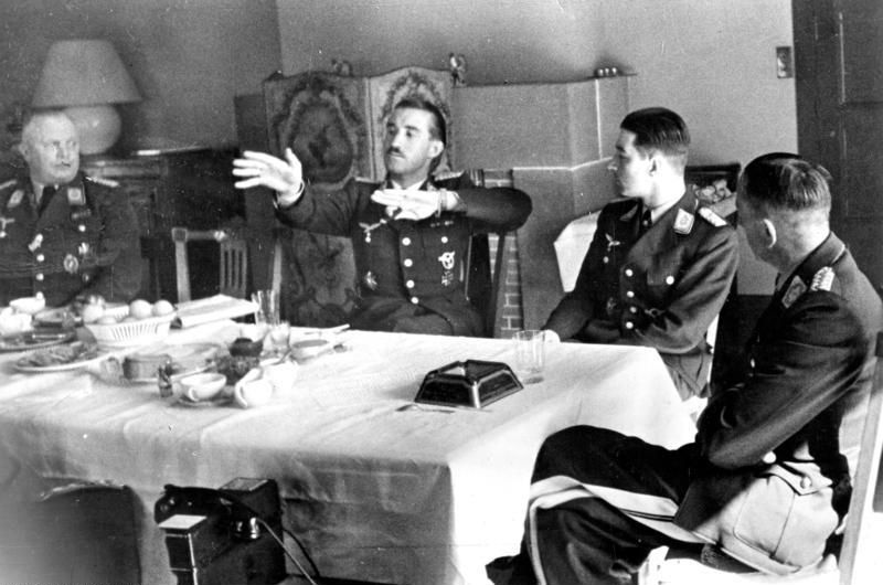 Adolf Galland gestykuluje w czasie urodzinowego przyjęcia innego asa Luftwaffe Theo Osterkampa. Kwiecień 1941 (źródło: Bundesarchiv; lic. CC ASA 3.0).