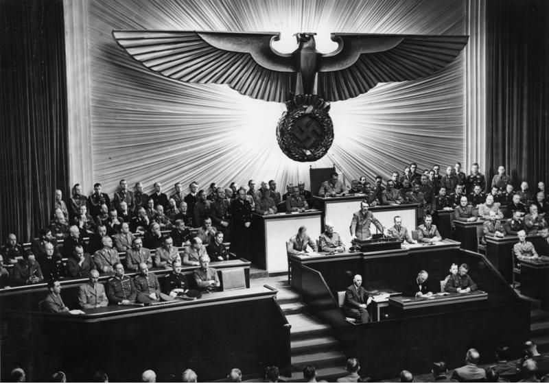 Hitler przemawiający do Reichstagu w grudniu 1941 roku. Przywódca Niemiec wciąż udawał demokratę, choć zgromadzenie nazywano dowcipnie "najdroższym chórem świata" (Bundesarchiv, Bild 183-1987-0703-507 / autor nieznany, lic. CC-BY-SA 3.0 de).