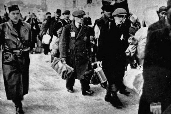 Słowaccy Żydzi przeznaczeni do deportacji pod strażą Hlinkowej Gwardii (źródło: domena publiczna).