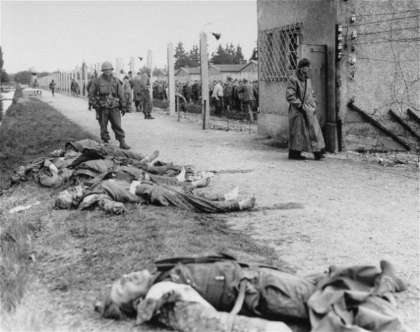 Amerykański żołnierz nad ciałami Niemców zabitych w czasie samosądu w Dachau (fot. National Archives and Records Administration, College Park Central Zionist Archives, domena publiczna)