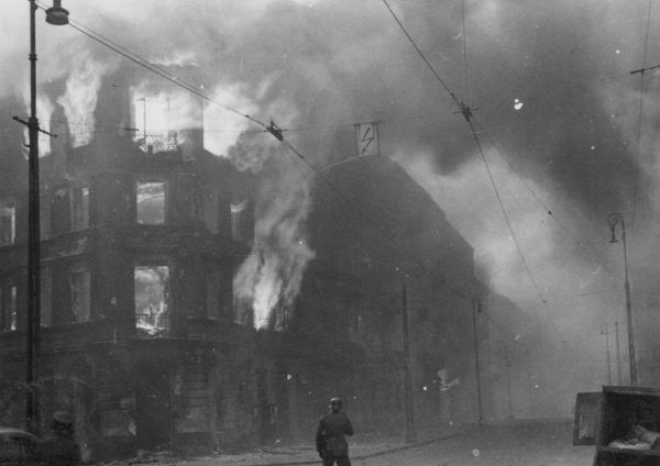 Czytając przejmujące "Pokolenie" warto pamiętać, że Baczyński napisał je, gdy płonęło warszawskie getto. Na zdjęciu podpalone przez Niemców kamienice na skrzyżowaniu ulic Zamenhofa i Wołyńskiej (źródło: domena publiczna). 