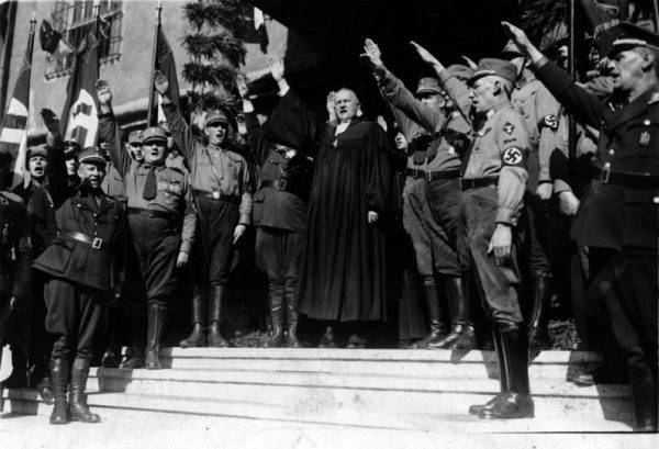 Otwarcie Narodowego Synodu w Wittenberdze. W środku Ludwig Müller, Reichsbischof Ewangelickiego Kościoła Niemieckiego i członek organizacji Deutsche Christen (źródło: Bundesarchiv, Bild 183-H25547, licencja: CC-BY-SA 3.0).