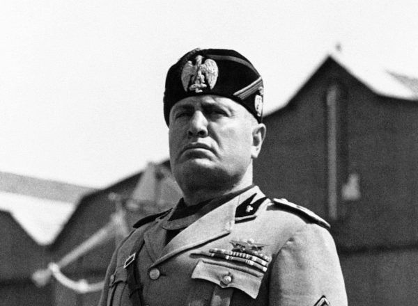 Benito Mussolini podczas jednego ze swych licznych przemówień. Z jego twarzy promieniuje spokój. Wie że nic mu nie grozi, wszak kule się go nie imają (źródło: domena publiczna).