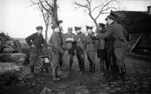 Na fotografii Bronisław Kamiński rozmawia z niemieckimi policjantami i członkami RONA podczas antypartyzanckiej akcji na Białorusi w 1944 roku. 