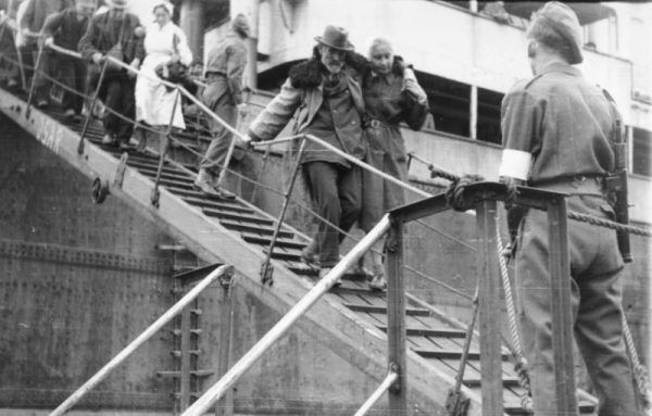 Niemieccy uchodźcy schodzą ze statku w porcie zajętym przez wojska brytyjskie.