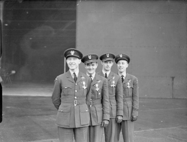 Na zdjęciu Witold Urbanowicz, Jan Zumbach, Mirosław Ferić, Zdzisław Henneberg z przypiętymi brytyjskimi odznaczeniami po ceremonii ich wręczenia. (domena publiczna)