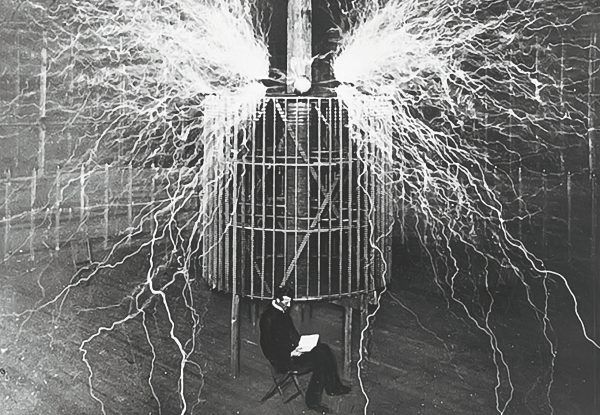 Nikola Tesla na tle swojego słynnego wynalazku.