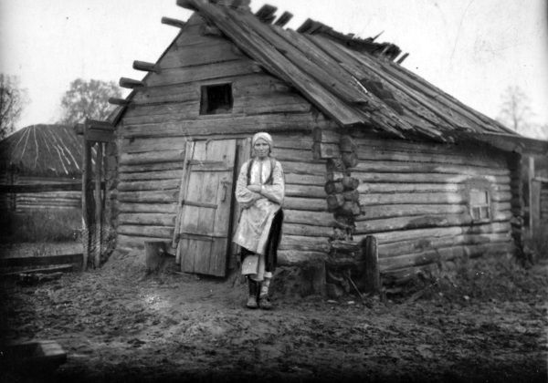 Kobieta z powiatu sarneńskiego obok swojego walącego się domu. Choć dziś nie chcemy o tym pamiętać, ogromne rzesze ludności żyły w skrajnej biedzie.