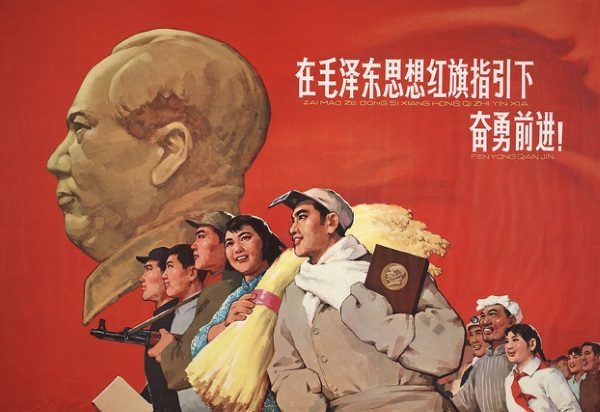 Chiński plakat propagandowy. Na pierwszym planie człowiek niosący książeczkę z cytatami z Mao (fot. domena publiczna)