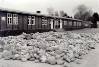 Przed jednym z baraków odwiedzający obóz Żydzi zostawiają kamienia na uczczenie pamięci zabitych tu ofiar.
