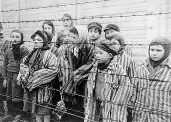Dzieci za drutami obozu. Kadr z filmu sowieckiego dokumentującego wyzwolenie Auschwitz