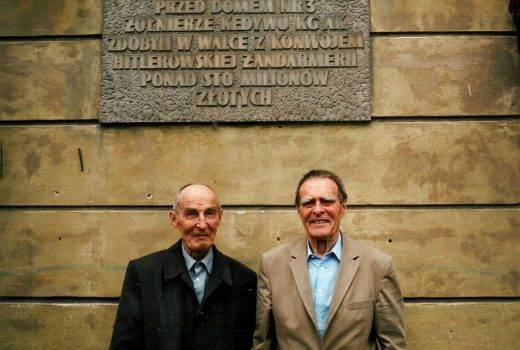 Dwaj ostatni żyjący (lipiec 2013) uczestnicy akcji „Góral” Tadeusz (z lewej) i Andrzej Żupańscy pod tablicą pamiątkową w miejscu akcji